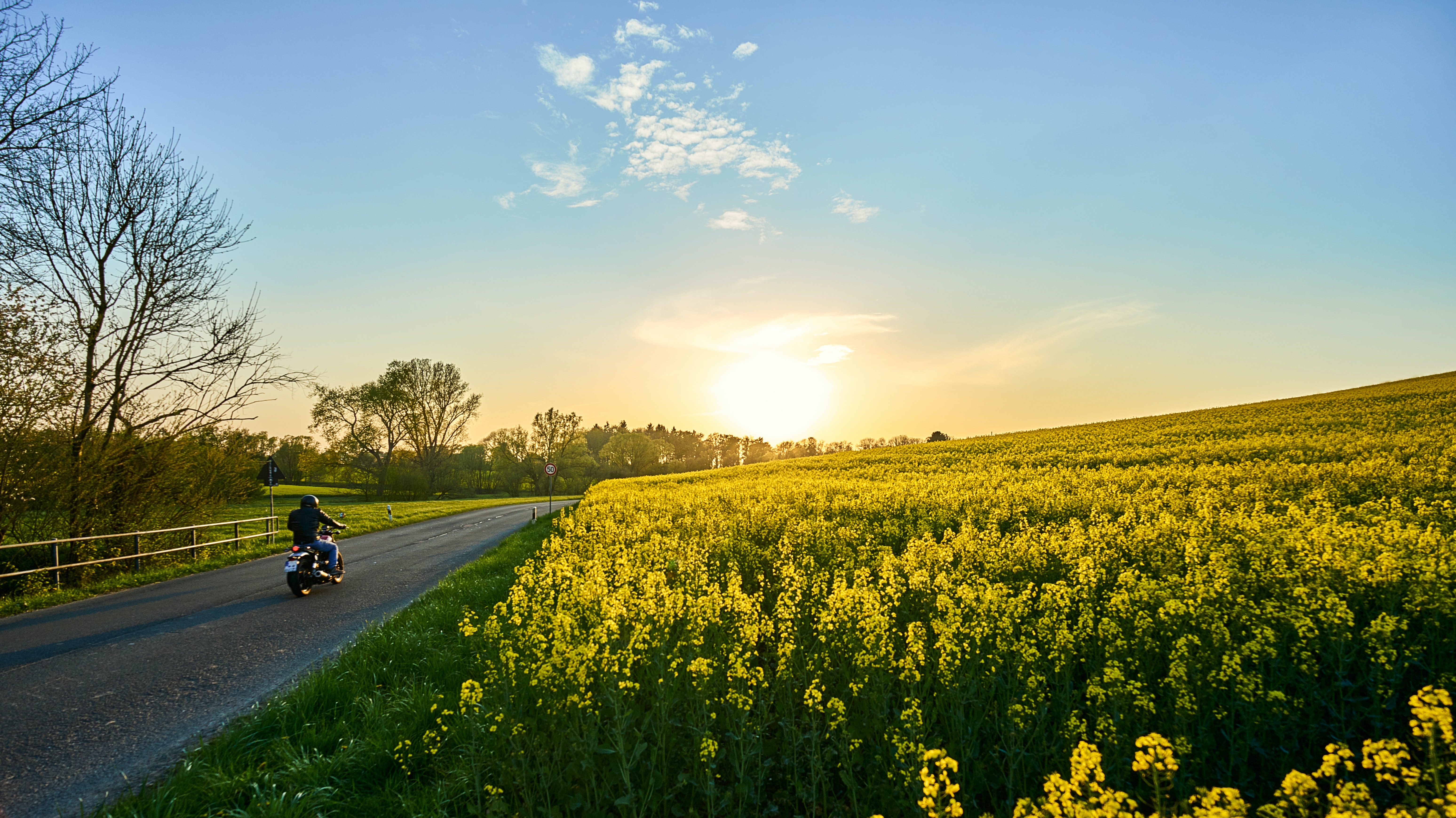 motorcycle rider on a dirt road at sunset