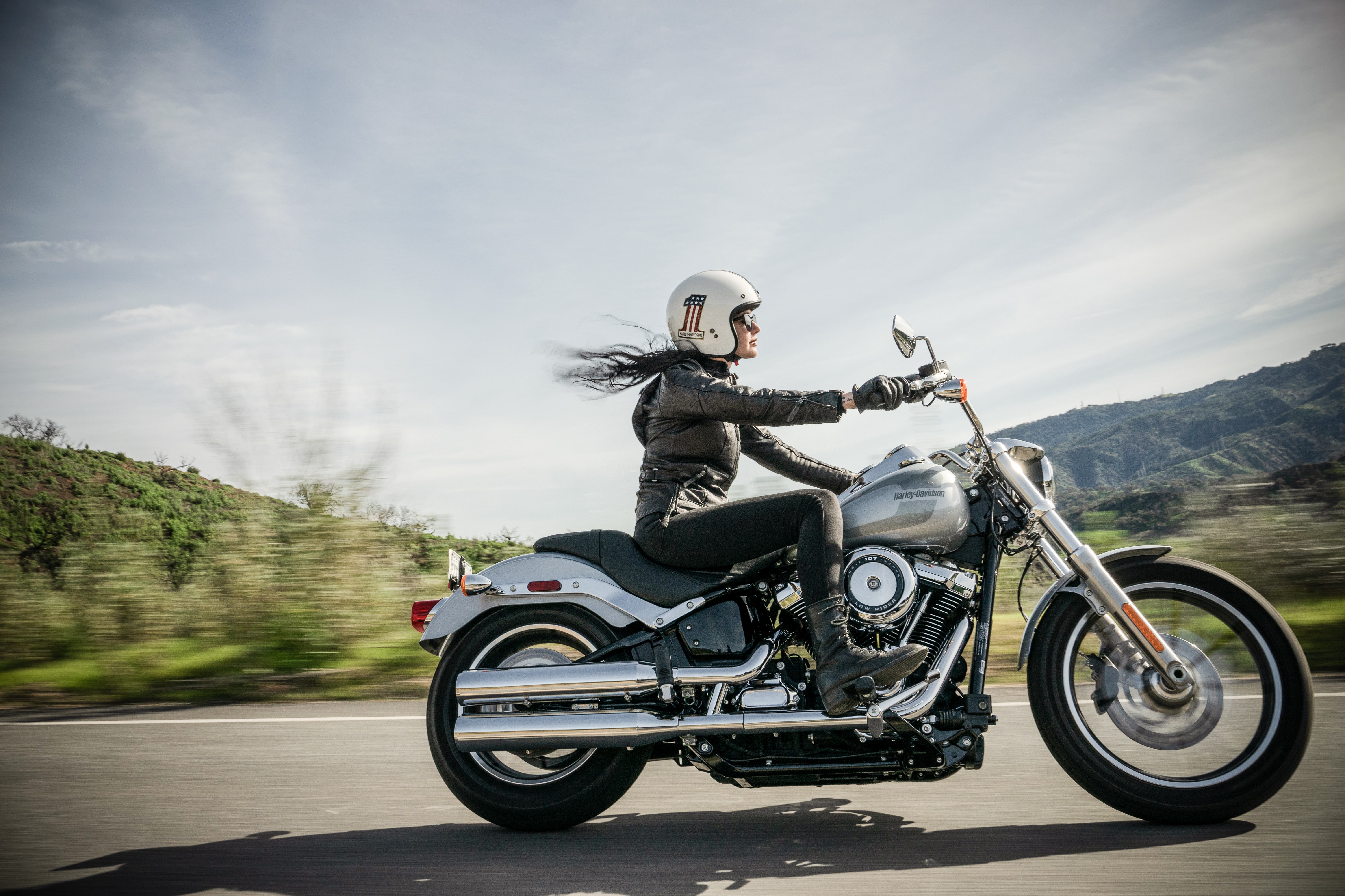 Woman cruising on her motorcycle with her hair flying in the wind.